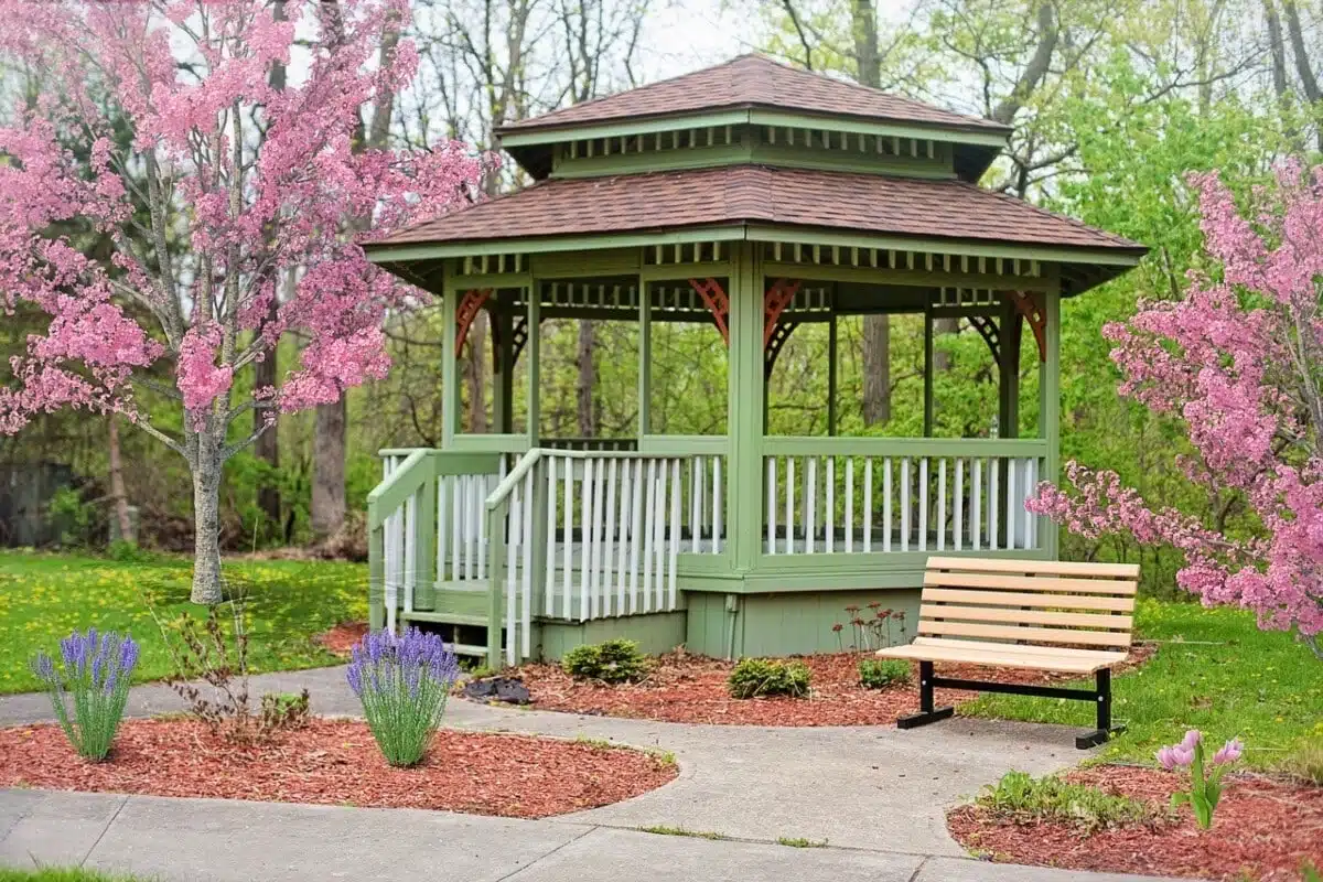 Green backyard gazebo with bench